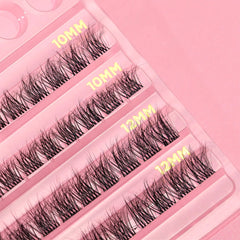 Close-up of a tray featuring several rows of Doll Beauty Individual Lash - 02 Natural false eyelashes in varying lengths. The rows are labeled with gold text as