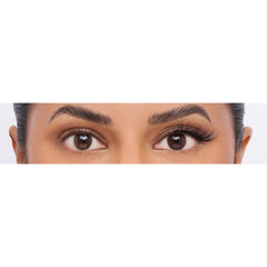A close-up of a woman's eyes and eyebrows shows the left eyebrow neatly groomed, while the right remains full and thick. Her open eyes are accentuated with Eylure 3/4 Length Lashes - 024, creating a subtle cat-eye effect that highlights her natural beauty against a light background.