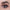 A close-up of a person's eye showcases a brown iris enhanced by shimmery copper eyeshadow. The eyelid is accentuated with voluminous Ardell Faux Mink Lashes in Black Demi Wispies, and the brow is expertly defined. The overall makeup elegantly highlights the eye's natural beauty.