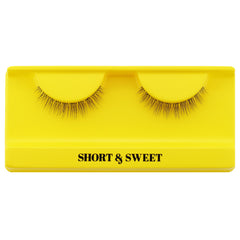 A pair of Boldface Lashes - Short and Sweet cruelty-free false eyelashes is showcased on a bright yellow tray with the words