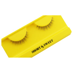 A pair of Boldface Lashes - Short and Sweet is showcased on a vibrant yellow card. These cruelty-free lashes present a natural look and are meticulously arranged, providing an ideal mixture of subtlety and style.