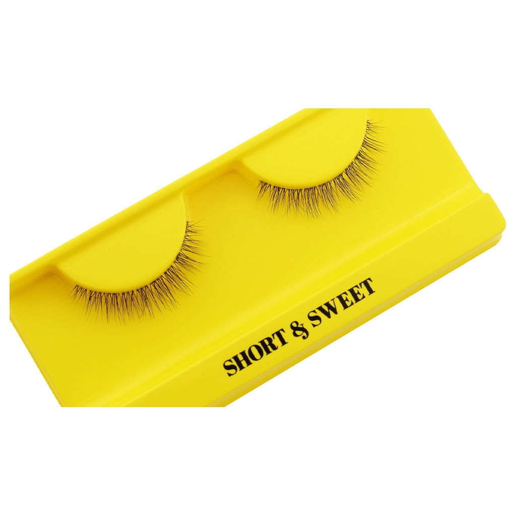 A pair of Boldface Lashes - Short and Sweet is showcased on a vibrant yellow card. These cruelty-free lashes present a natural look and are meticulously arranged, providing an ideal mixture of subtlety and style.