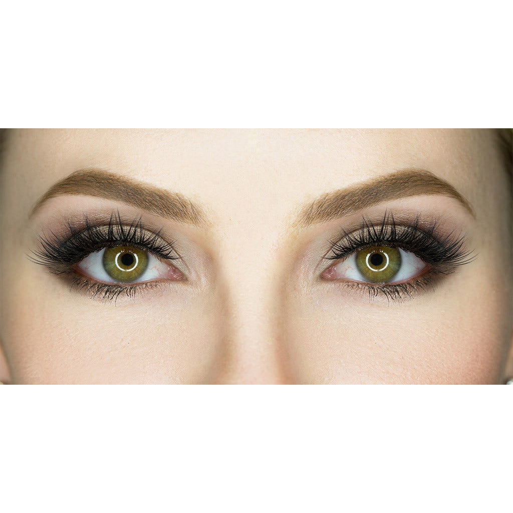 Close-up image of a person's eyes with striking green irises, framed by House of Lashes' iconic lashes. The thick, dark lashes and well-defined eyebrows are enhanced by subtle eyeshadow and black eyeliner, giving the eyes a bold and captivating appearance.