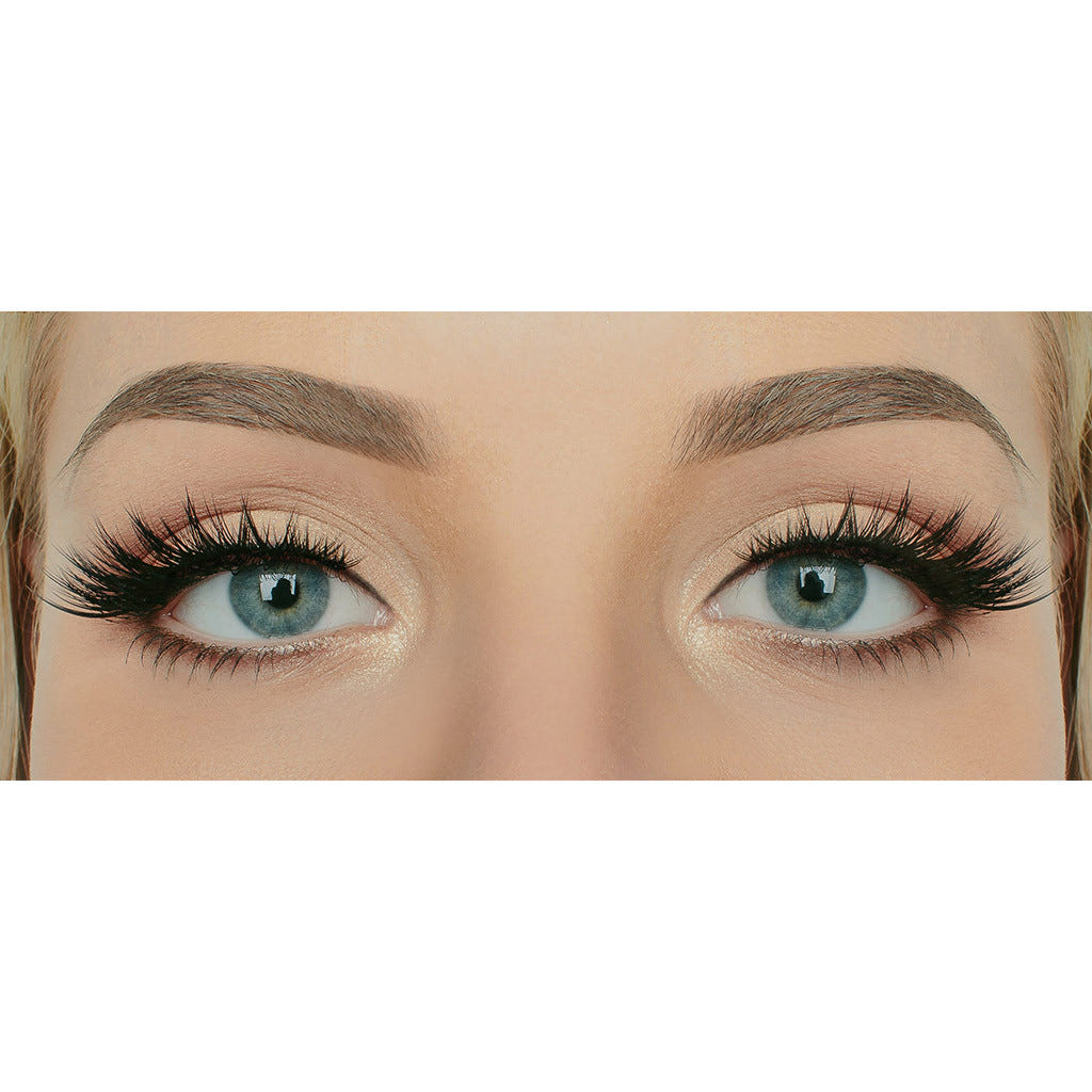 Close-up of a person's eyes with thick, full eyelashes and perfectly shaped eyebrows. The blue eyes are highlighted by subtle eyeshadow, and the Iconic lashes from House of Lashes appear to be enhanced with cruelty-free mascara or false lashes, creating a dramatic, defined look.