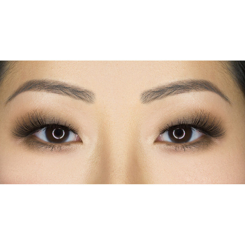 Close-up of a pair of brown eyes with long, dramatic eyelashes from House of Lashes - Siren and well-groomed eyebrows. The eyelids are adorned with subtle, smoky eye makeup, enhancing the natural shape and depth of the eyes. The skin appears smooth and well-lit.